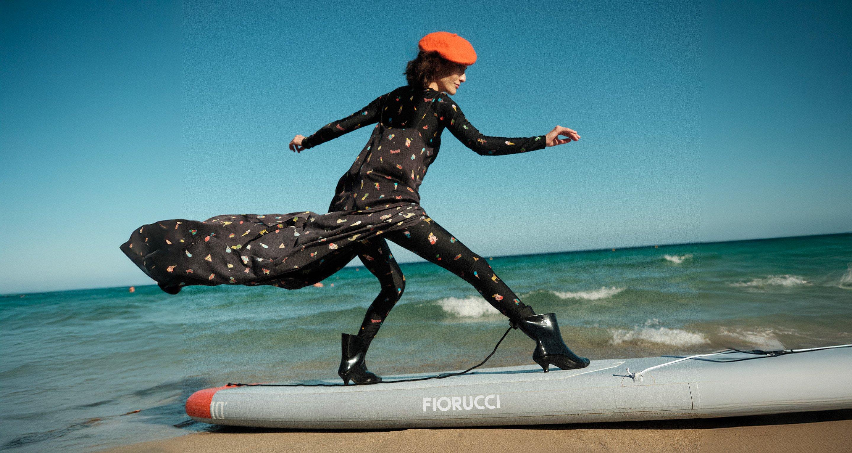 The model is wearing the Toys Print Slip Maxi Dress in Black, Toys Print Leggings in Black, Toys Print Long Sleeve Crop Top in Black, Love Boots in Yellow.